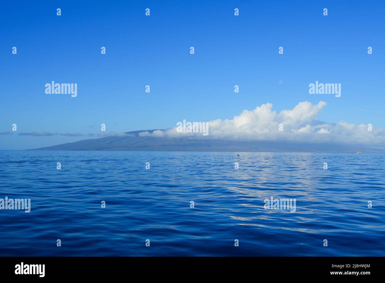 Île de Lanai dans l'archipel hawaïen par une belle journée d'hiver avec des nuages attachés à ses montagnes Banque D'Images