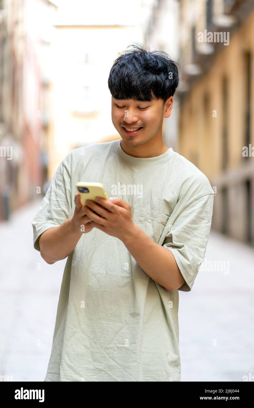 joyeux asiatique avec son nouveau smartphone Banque D'Images