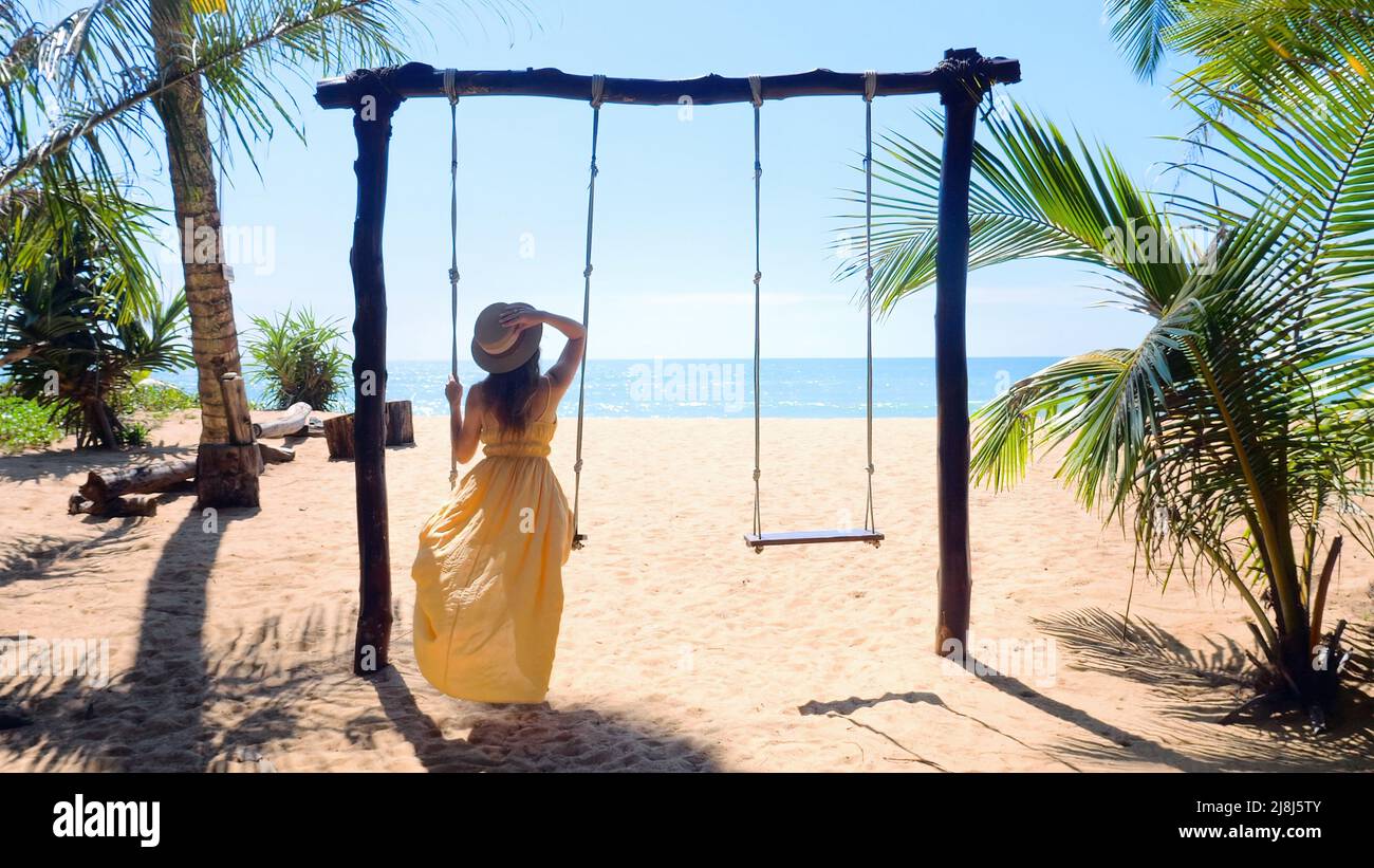 Femme avec chapeau profitant de la liberté sur swing à Phuket, Thaïlande. Concept de voyage Banque D'Images