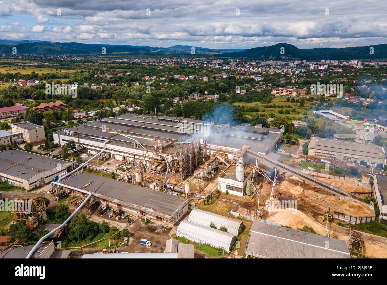 Vue aérienne de l'usine de traitement du bois avec fumkestack à partir de l'environnement polluant du procédé de production dans le chantier de fabrication en usine Banque D'Images