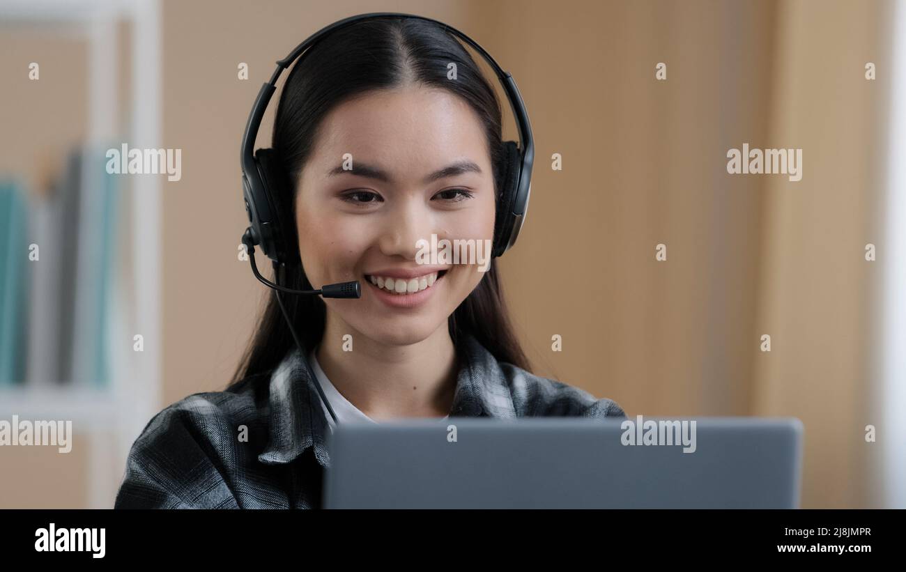 Portrait asiatique femme étudiante fille en ligne professeur distant porter casque parler conférence téléphonique parler regardant l'ordinateur portable à la maison bureau vidéo chat travail Banque D'Images