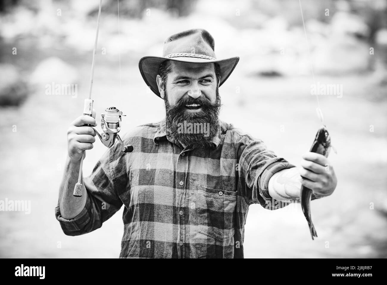 Attraper un gros poisson avec un poteau de pêche. Poisson sur le crochet. Pêche à la mouche. Tenue de truite brune. Pêche à la bobine. Concepts de réussite Banque D'Images