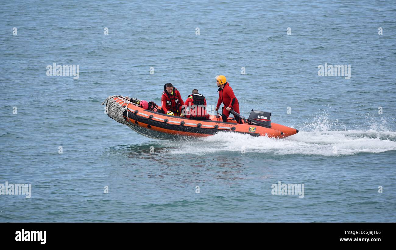 Trois sauveteurs de la sécurité civile naviguent dans un bateau gonflable pour secourir les personnes en détresse. Banque D'Images