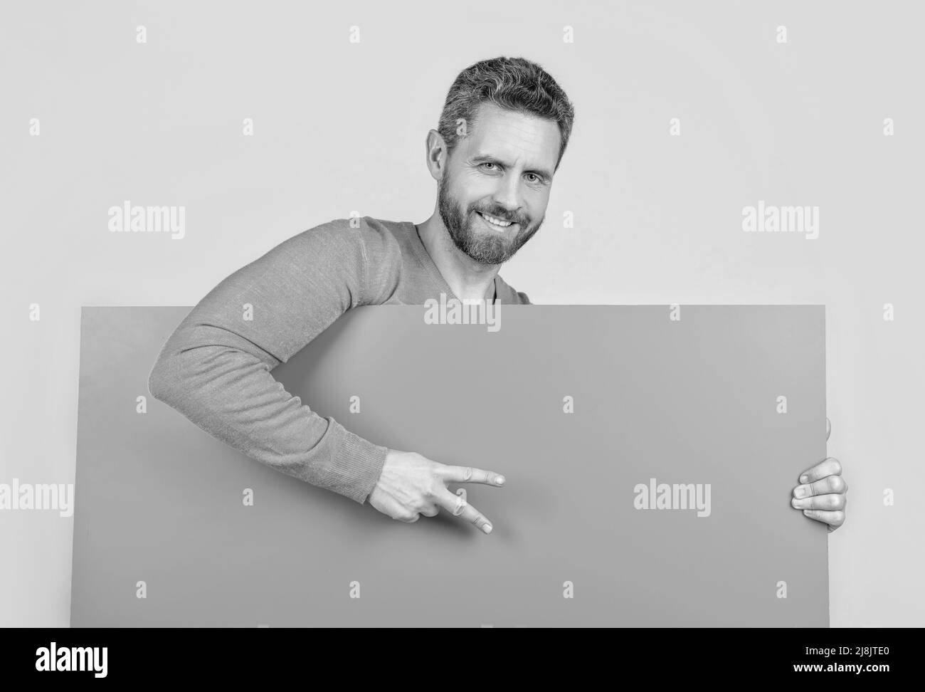 homme derrière une bannière en papier vierge avec un espace pour la copie de la publicité montre la paix geste, annonce. Banque D'Images