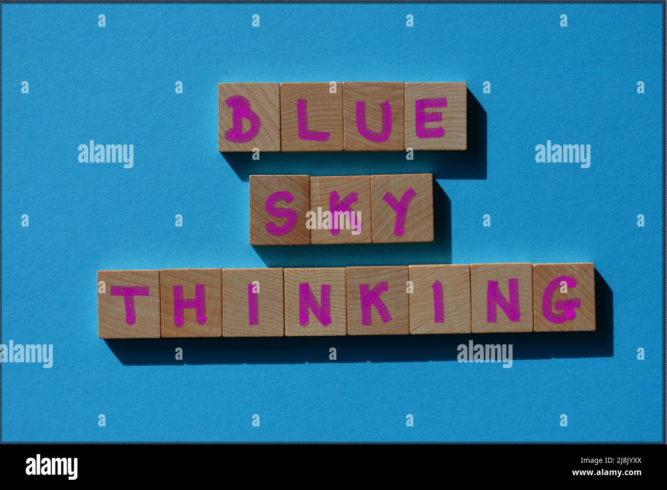 Blue Sky Thinking, mots en lettres de l'alphabet en bois isolées sur fond bleu Banque D'Images