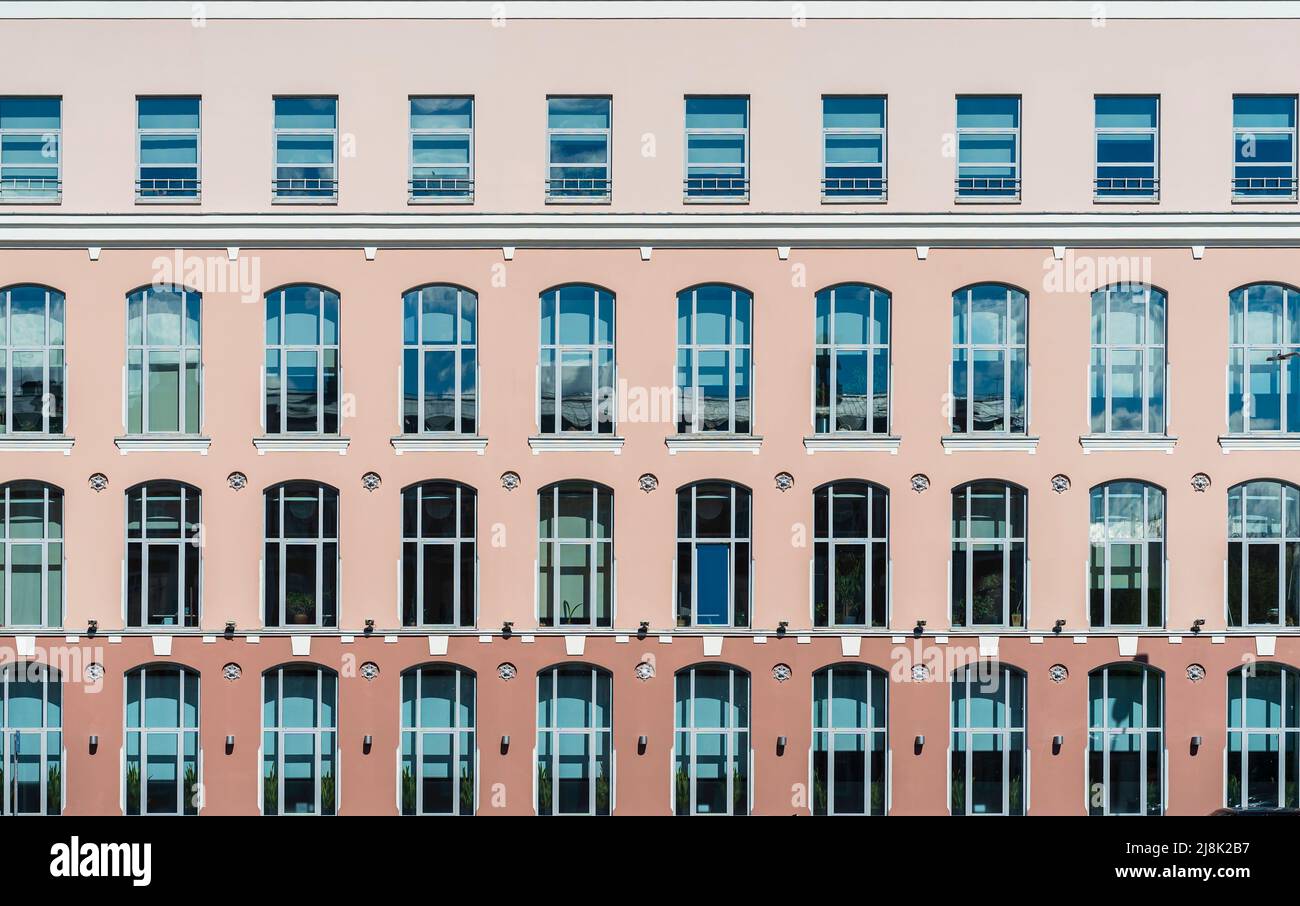 Arrière-plan du bâtiment. Vue géométrique stricte sur la façade des fenêtres sur un mur coloré, architecture moderne Banque D'Images