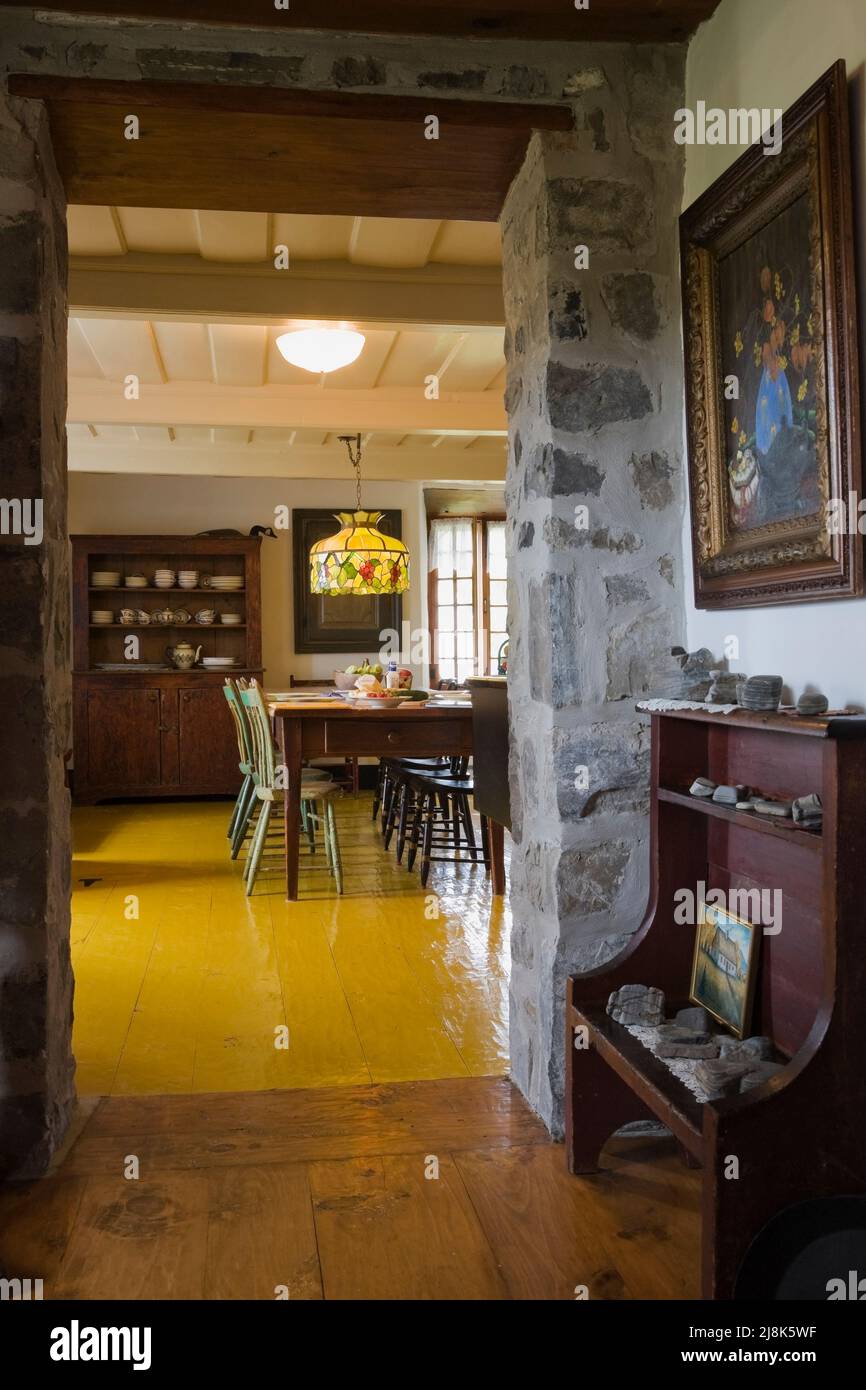 Ancien banc de seau dans le couloir menant à la cuisine à l'intérieur de la vieille maison de style cottage régime français vers 1780. Banque D'Images
