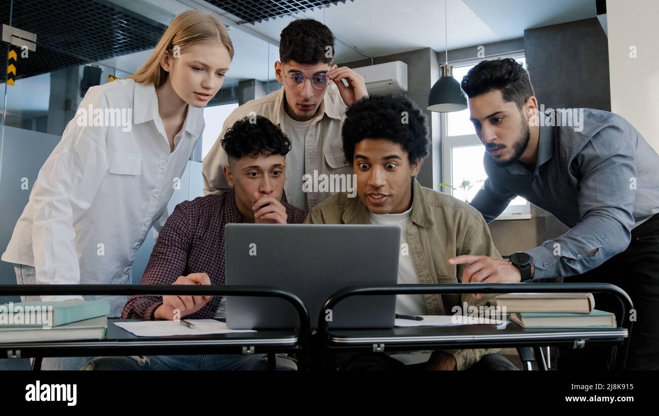 Jeunes enthousiastes heureux hommes d'affaires équipe dans le bureau regardant l'écran d'ordinateur portable de lecture bonne nouvelle groupe employés d'entreprise personnes célébrant professionnel Banque D'Images