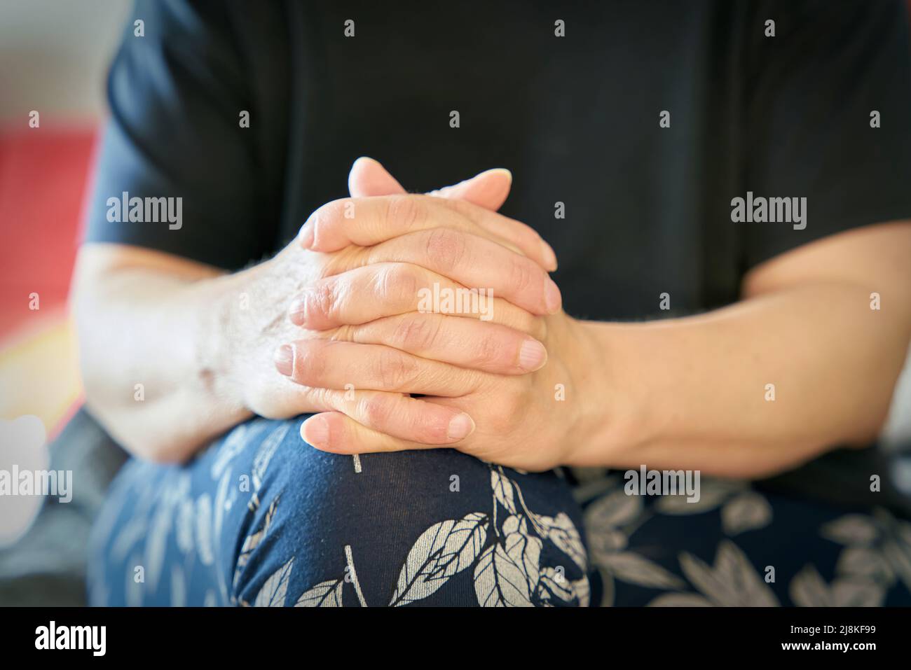 Une femme aux mains pliées est détendue et écoute la conversation Banque D'Images