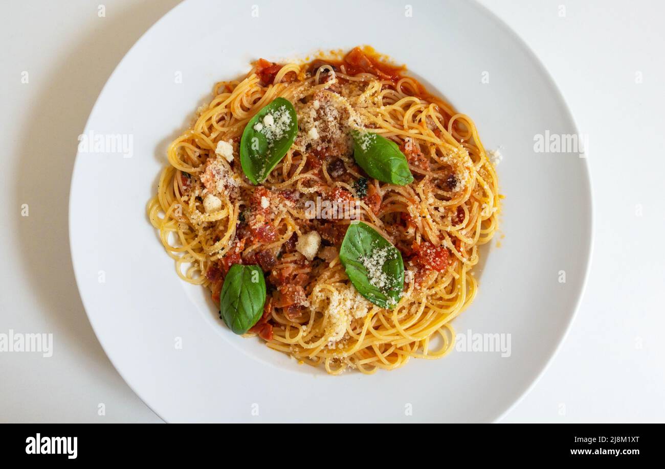 Pâtes Angel Hair dans une sauce tomate épicée et jambon avec basilic frais Banque D'Images