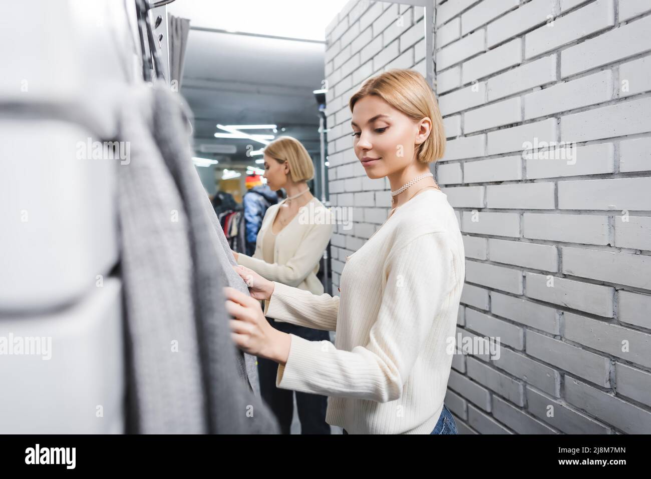 Jeune client regardant des vêtements flous dans le dressing de seconde main  Photo Stock - Alamy