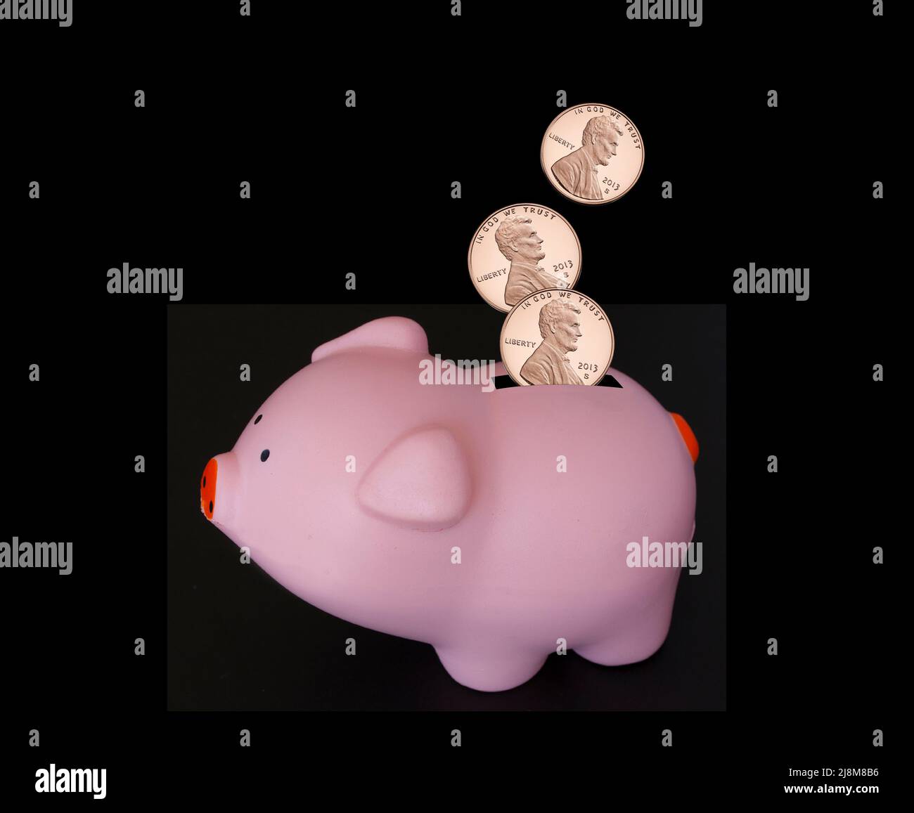 USA Cute Piggy Bank épargne argent. PIÈCES DE un cent US tombant dans une banque de porc rose isolée sur fond noir. Banque D'Images