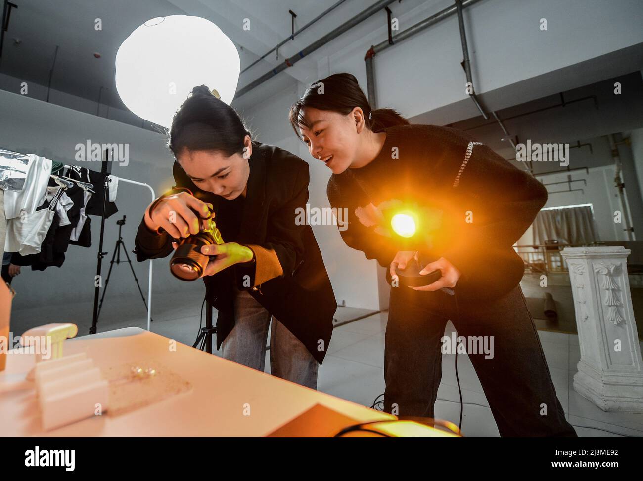 (220517) -- XILINGOL, 17 mai 2022 (Xinhua) -- Tergel (L) et Zhang Aoyu prennent des photos des accessoires en argent dans leur atelier de Xilinhot de la Ligue Xilingol, région autonome de la Mongolie intérieure de la Chine du nord, le 16 mai 2022. Tergel, une fille du groupe ethnique mongol, et Zhang Aoyu, tous nés en 1990s, ont été occupés avec leur accessoire d'argent faisant des affaires avec des caractéristiques mongoles à Xilinhot de la Ligue de Xilingol. Ils se connaissaient en tant qu'étudiants à l'Université normale de Mongolie intérieure en l'an 2014 et leurs intérêts communs dans les arts ethniques traditionnels ont fait les deux gi Banque D'Images