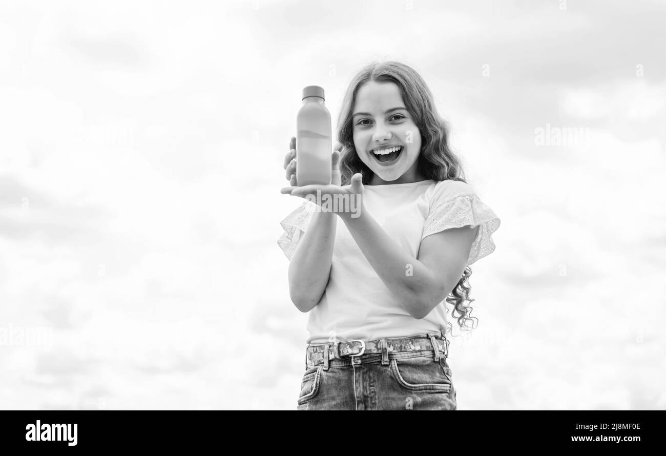 joyeux enfant présentant du jus ou de l'eau en bouteille pour rafraîchir, la vitamine Banque D'Images