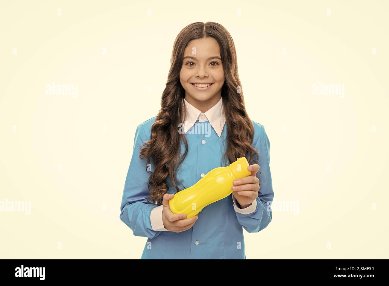 Happy Hungry fille tenir en plastique jaune bouteille avec le yogourt pour le repas de petit déjeuner sain, la faim Banque D'Images