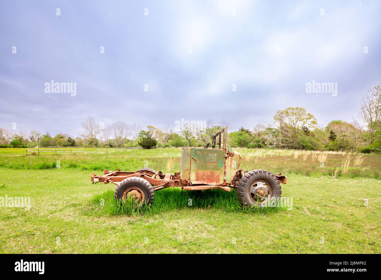 Un vieux véhicule assis dans un champ vert Banque D'Images
