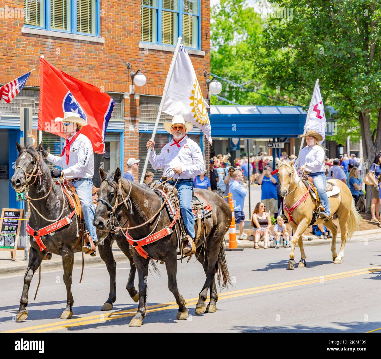 Des hommes sur des chevaux portant des drapeaux dans le Franklin Rodeo Parade Banque D'Images