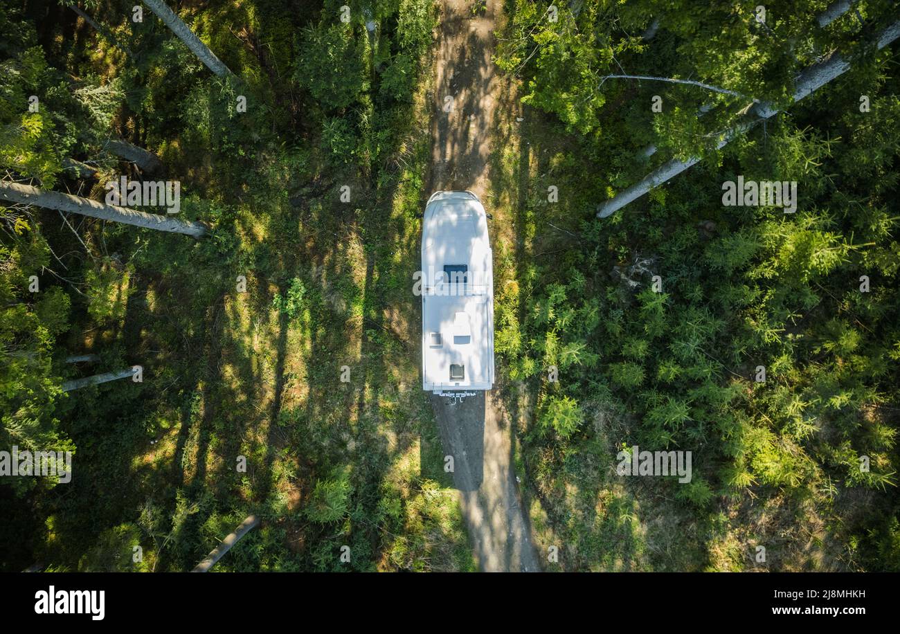 Fourgonnette camping-car de classe C sur une route de campagne en forêt vue aérienne. Voyage d'été en voiture. Banque D'Images