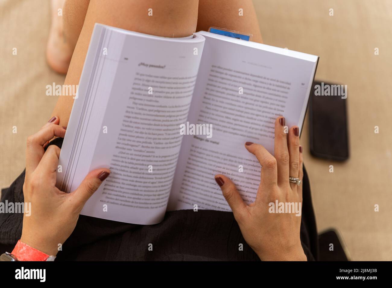 gros plan d'une femme avec un livre dans ses mains dans un lit de plage Banque D'Images