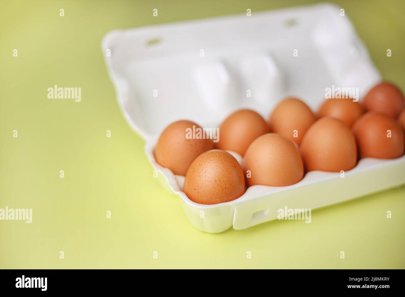Faire dorer les œufs dans un emballage en polystyrène expansé sur un fond jaune clair isolé Banque D'Images