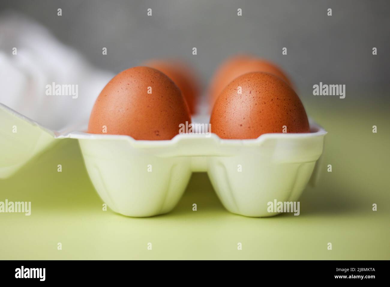 Faire dorer les œufs dans un emballage en polystyrène expansé sur un fond jaune clair isolé Banque D'Images