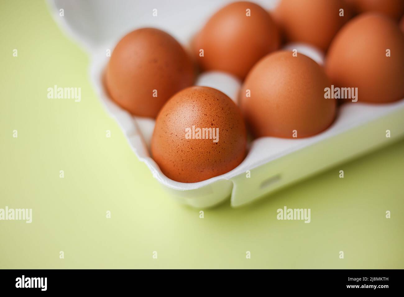 Faire dorer les œufs dans un emballage en polystyrène expansé sur un fond jaune clair isolé Banque D'Images