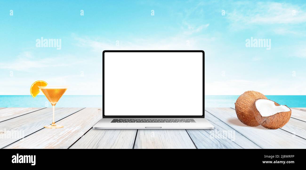 Ordinateur portable avec écran isolé et propre sur un bureau en bois avec la mer en arrière-plan Banque D'Images