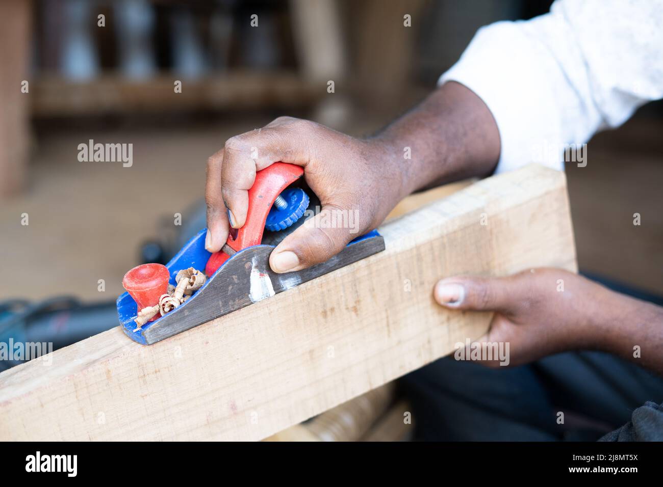 Gros plan des mains de Carpenter occupé à travailler en utilisant le plan de bloc pour enlever les surfaces rugueuses sur le bois à la boutique - concept d'artisans, indépendants et Banque D'Images