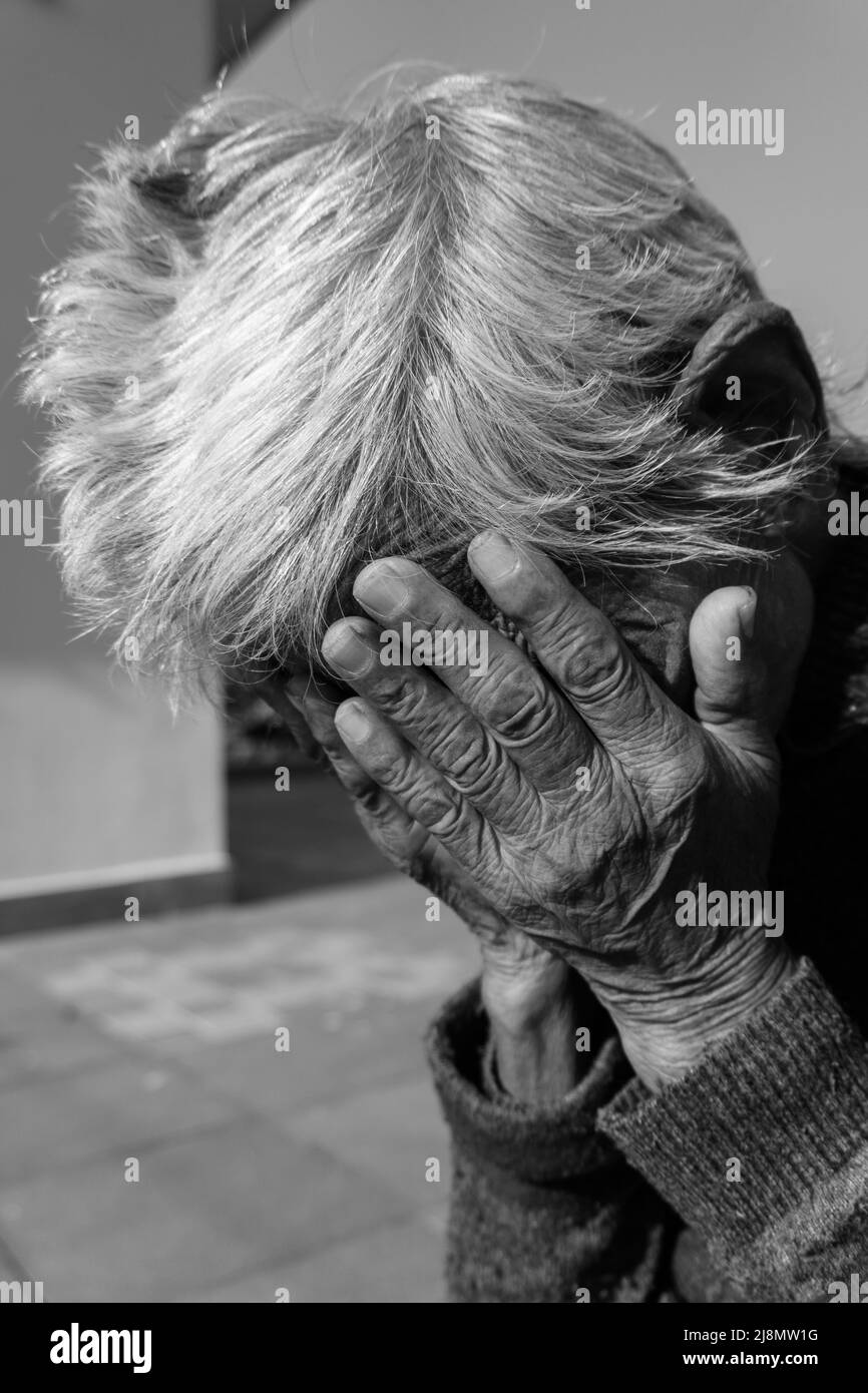 28th septembre 2020. Uttarakhand, Inde. Une photo en noir et blanc d'une vieille dame indienne ayant ses mains froissées sur son visage dans le désespoir. Banque D'Images
