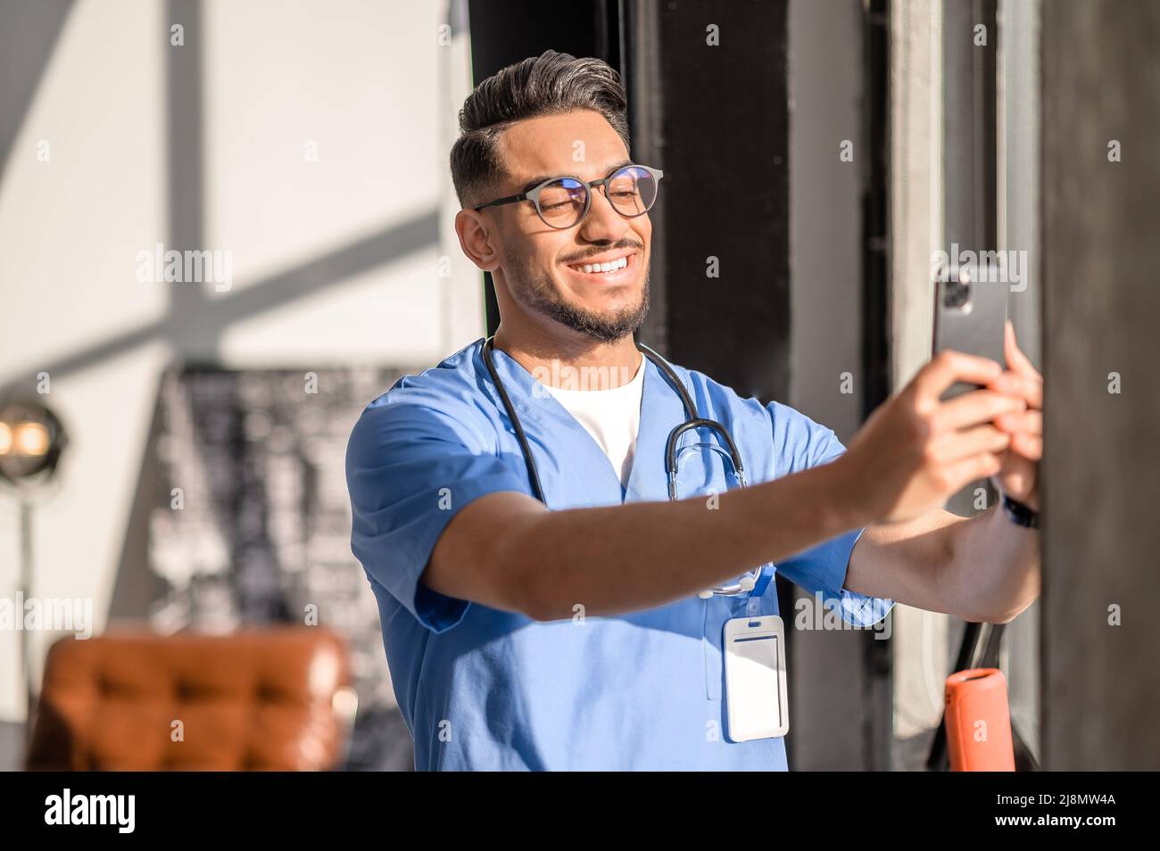 Médecin avec un sourire radieux prenant des photos de lui-même Banque D'Images