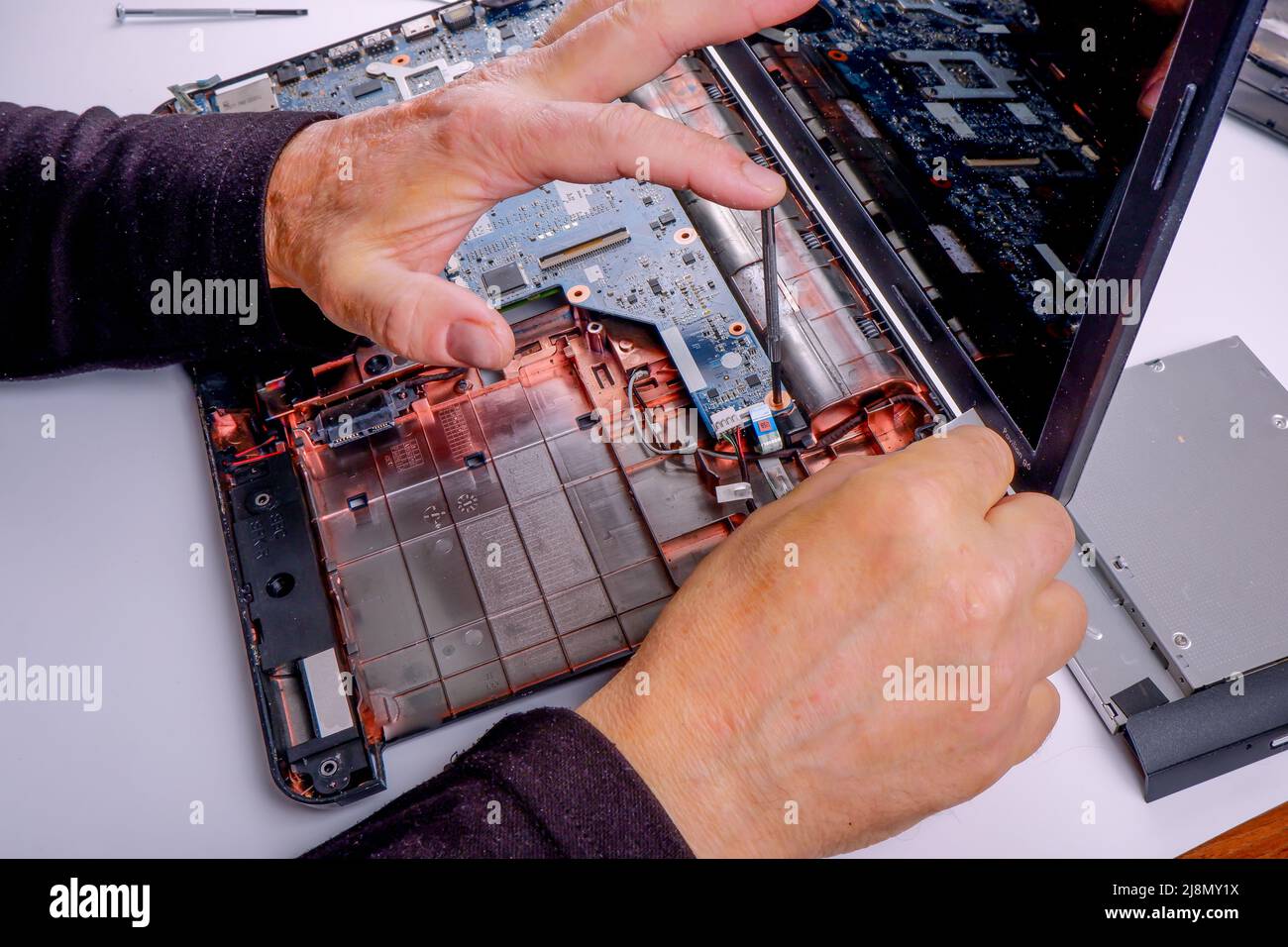 un réparateur informatique désassemble, répare et effectue la maintenance préventive d'un ordinateur portable cassé. Banque D'Images