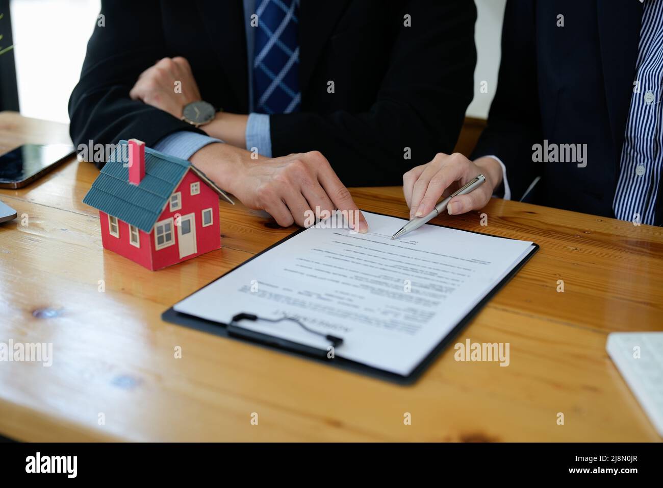 L'agent immobilier a parlé des conditions de l'accord d'achat de la maison et a demandé au client de signer les documents pour faire le contrat légalement Banque D'Images