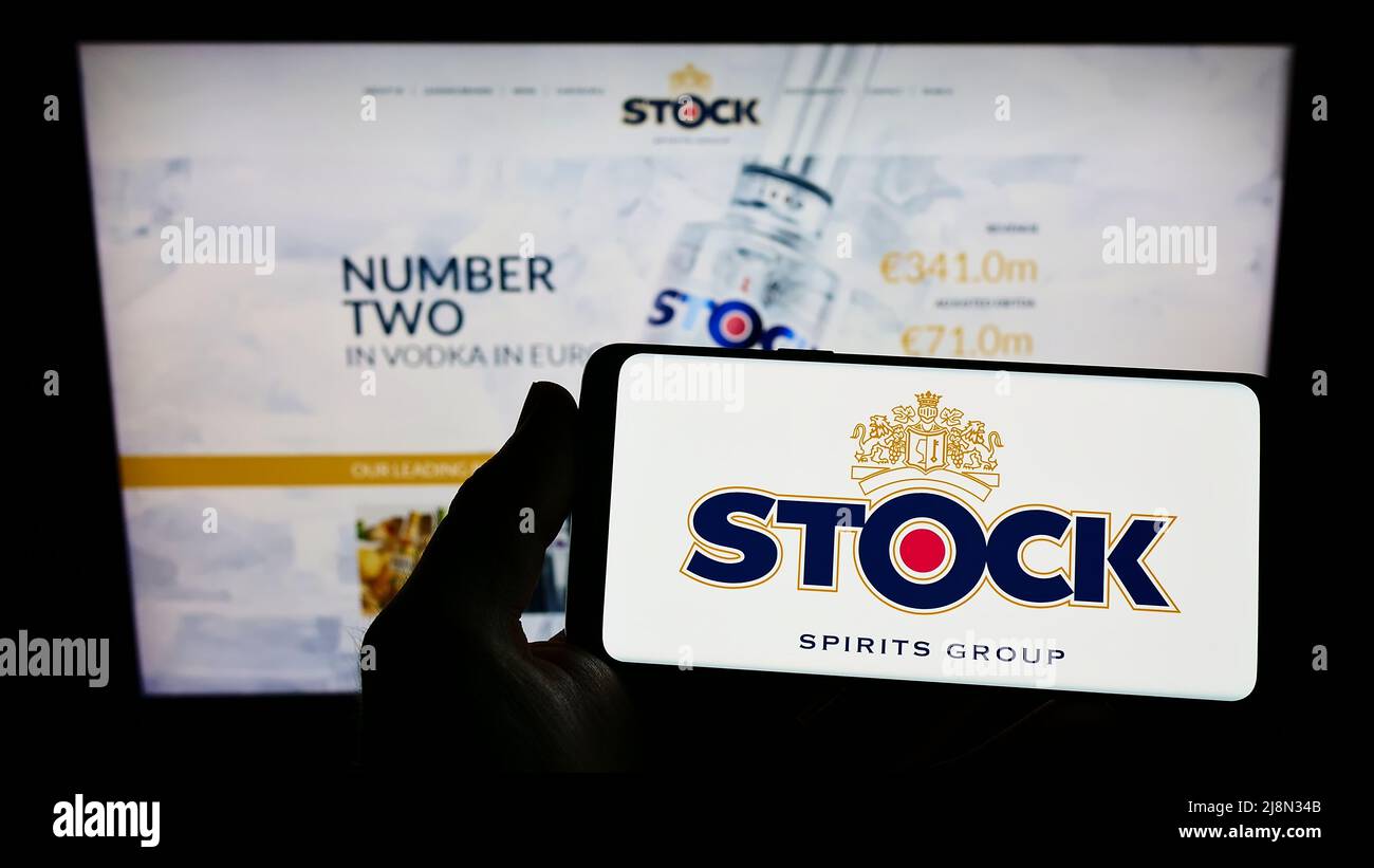 Personne détenant un smartphone avec le logo de la société britannique stock Spirits Group plc à l'écran devant le site Web. Mise au point sur l'affichage du téléphone. Banque D'Images