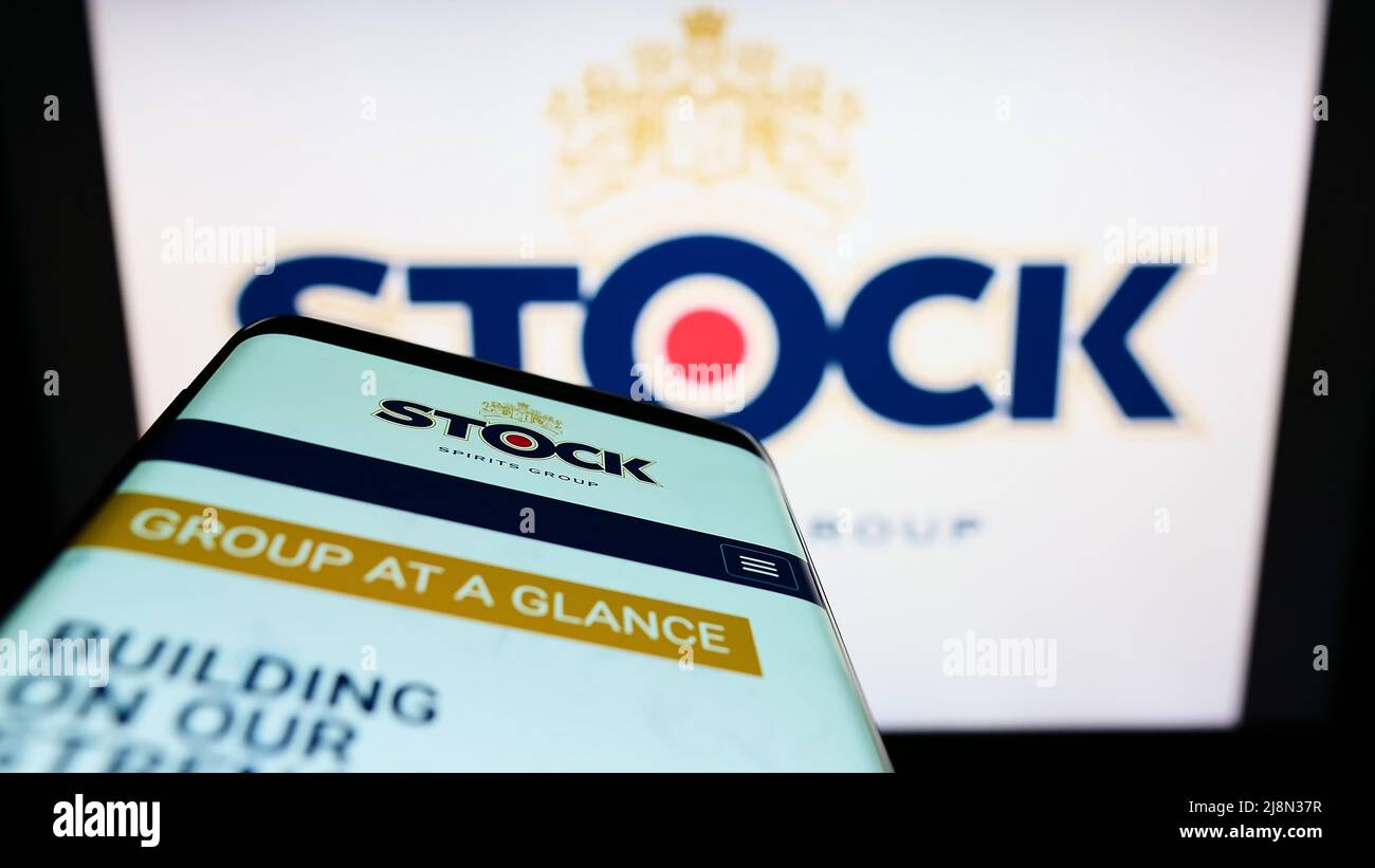 Smartphone avec la page Web de la société britannique stock Spirits Group plc à l'écran devant le logo de l'entreprise. Faites la mise au point dans le coin supérieur gauche de l'écran du téléphone. Banque D'Images