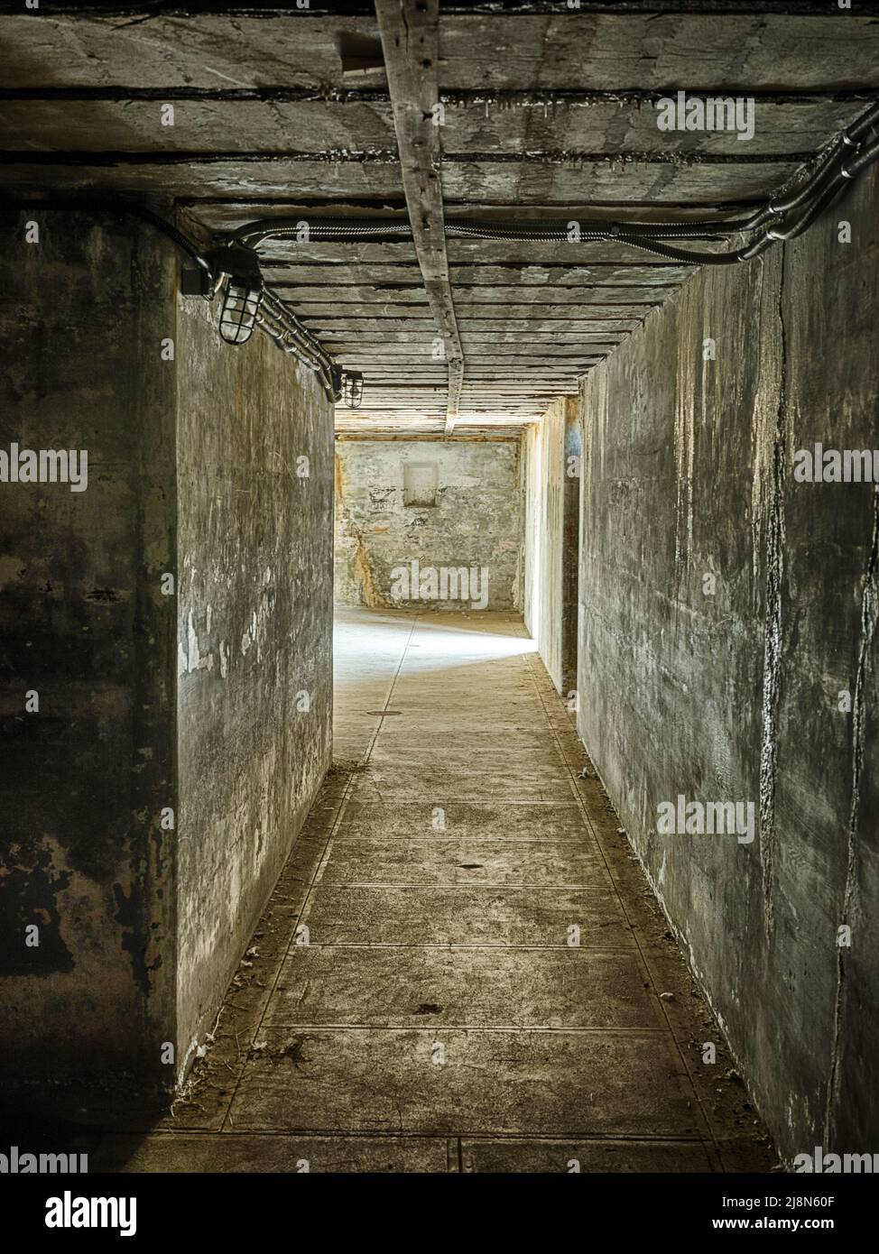 Un long couloir au rez-de-chaussée des ruines de fort Casey se termine en lumière de l'extérieur. Banque D'Images