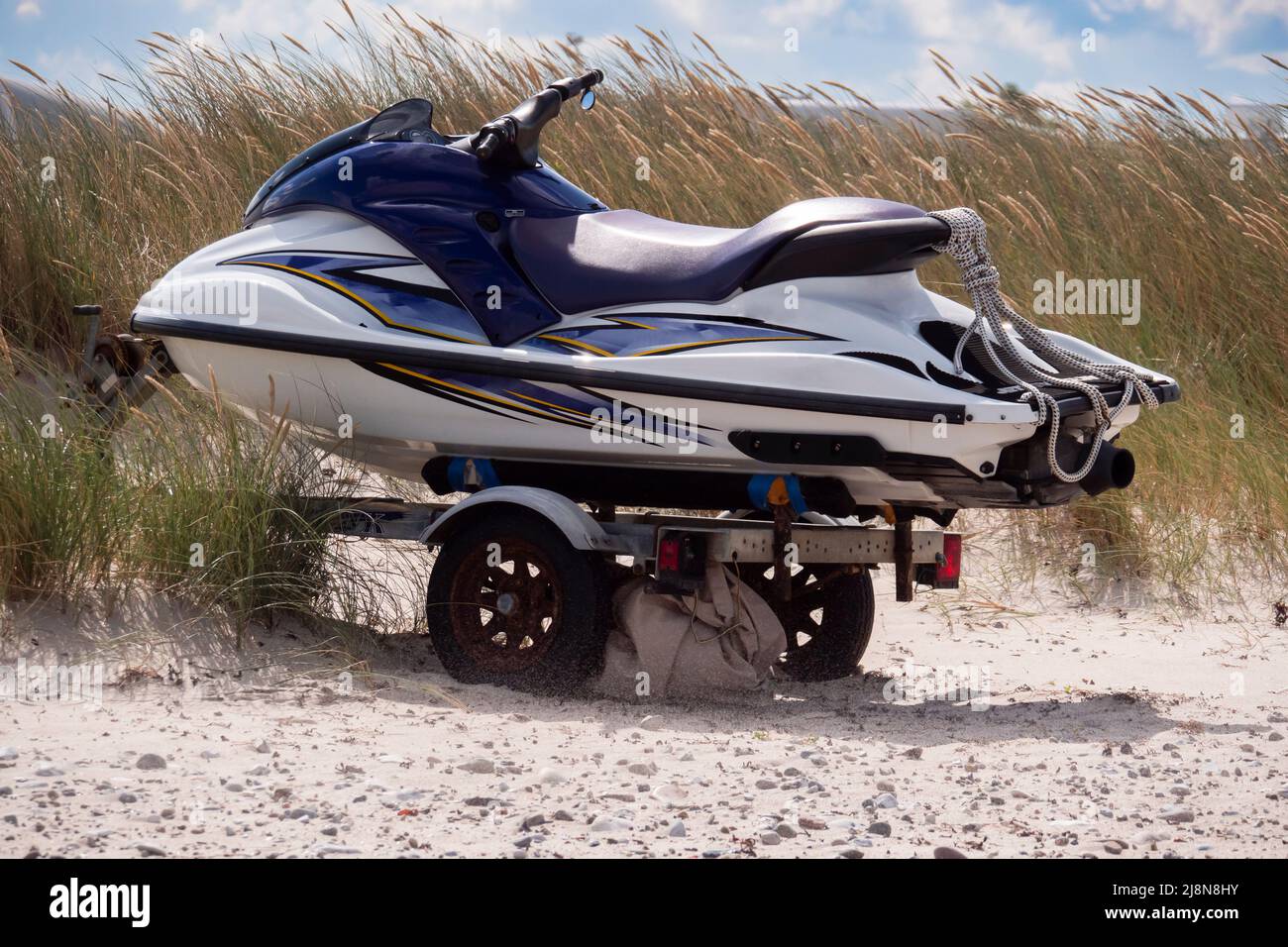 Jetbike sur une remorque de transport sur la plage de sable en face de l'herbe de maram Banque D'Images
