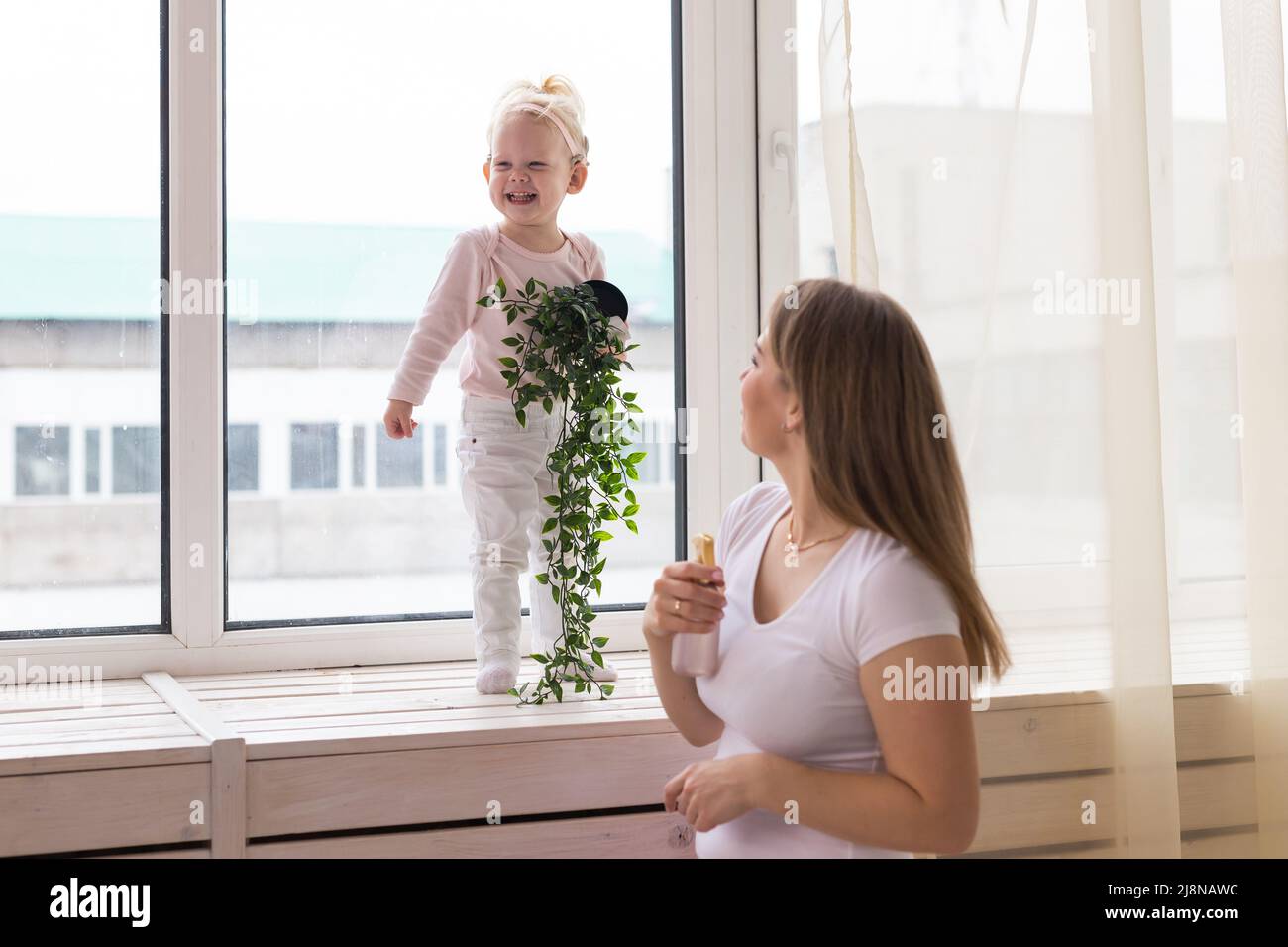 Enfant fille avec implant cochléaire avec sa mère à la maison. Notion de déficience auditive et de communauté sourde. Banque D'Images