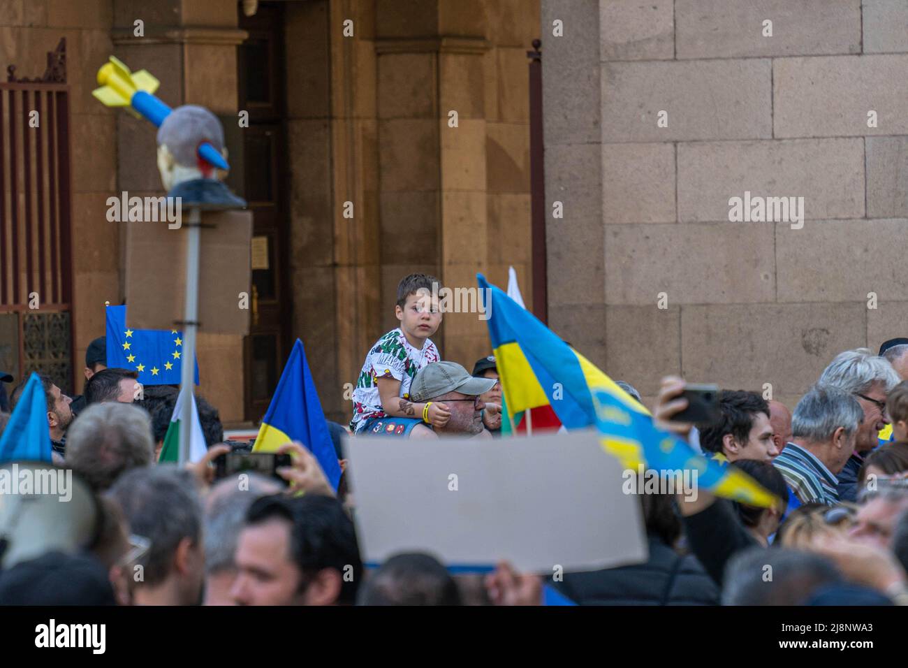 Sofia, Bulgarie - 09 mai 2022 : un garçon s'assoit sur les épaules de son père parmi les drapeaux de la manifestation Banque D'Images