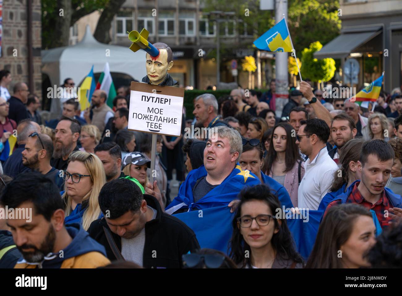 Sofia, Bulgarie - 09 mai 2022 : un homme dans une foule regarde la tête de Poutine surmontée d'un missile et les mots en russe : Poutine, c'est ce que je suis Banque D'Images