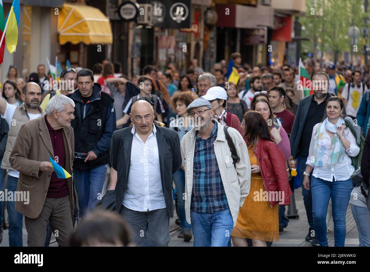 Sofia, Bulgarie - 09 mai 2022: Trois hommes matures marchent ensemble près de la rue bondée, discutant quelque chose les uns avec les autres amicaux Banque D'Images