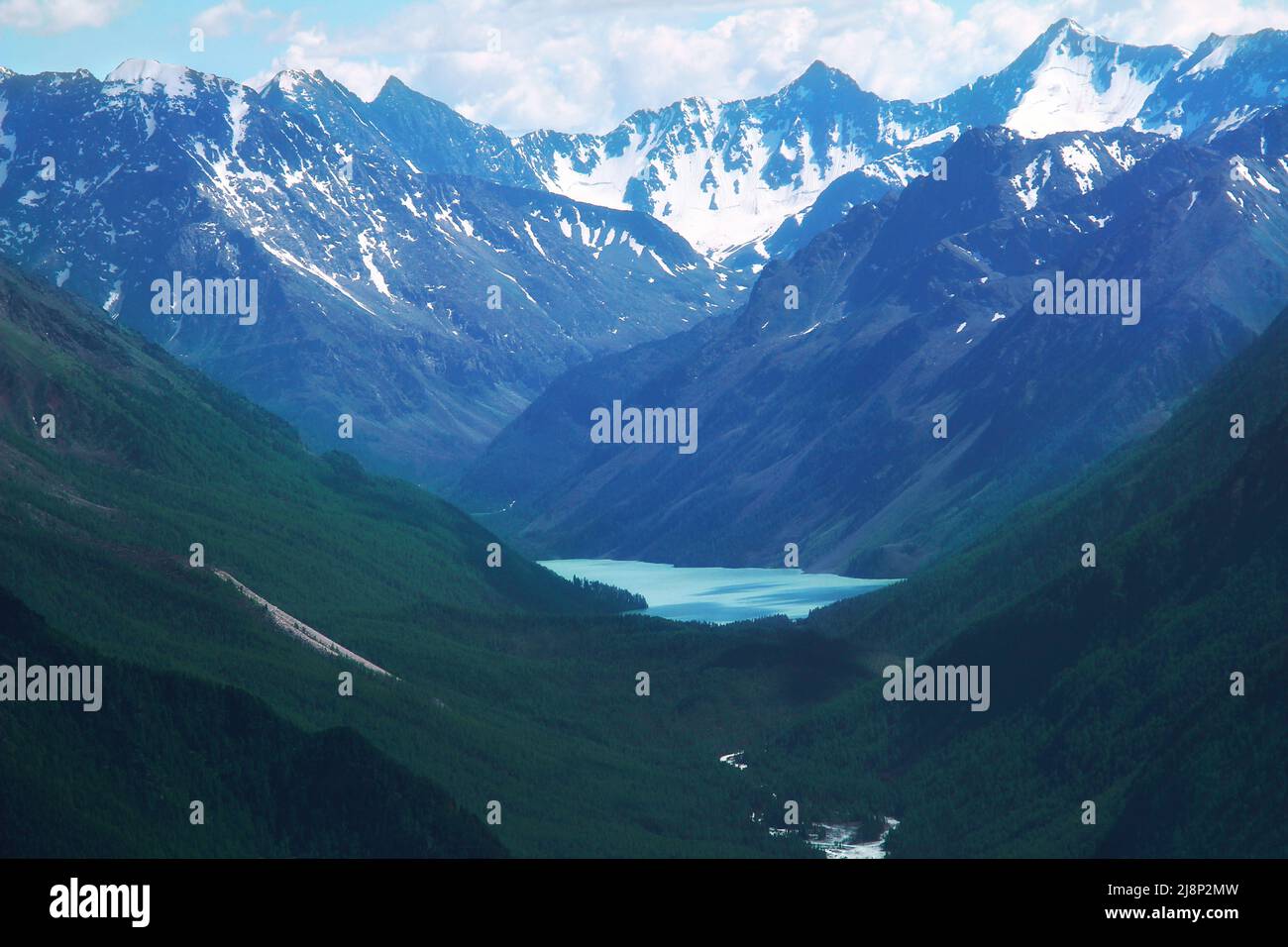 Alpine beau lac bleu en Altai dans une gorge de montagne avec de hautes montagnes avec des sommets enneigés en été Banque D'Images