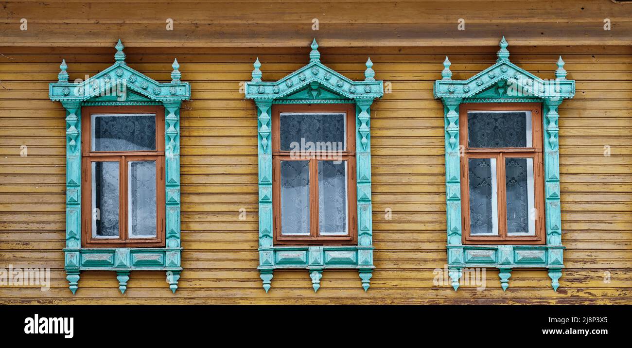 Trois vieilles fenêtres avec des architraves en bois sculpté sur
