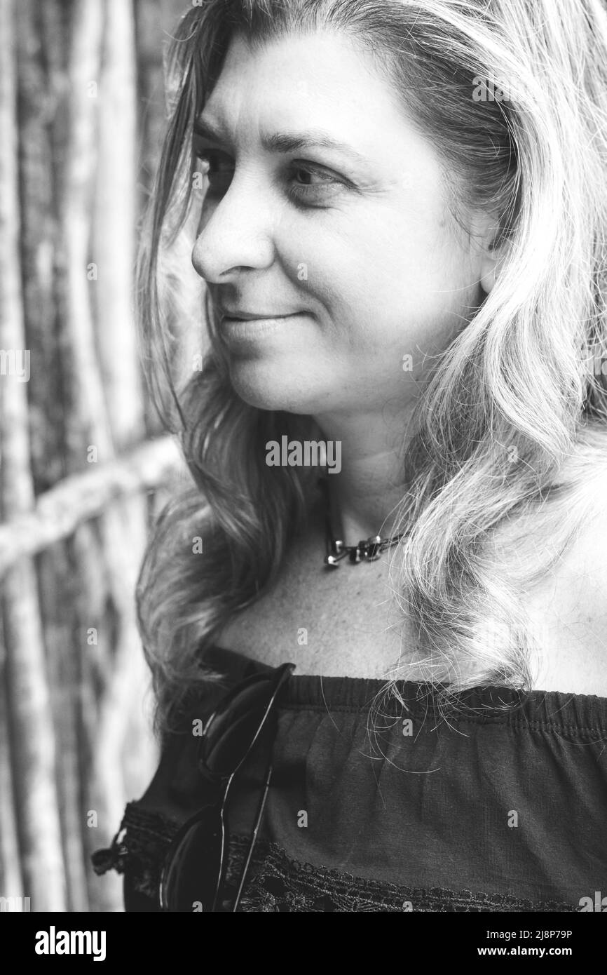 Portrait d'une femme debout regardant sur le côté contre un fond de bois. Maragogipinho, Bahia, Brésil. Banque D'Images