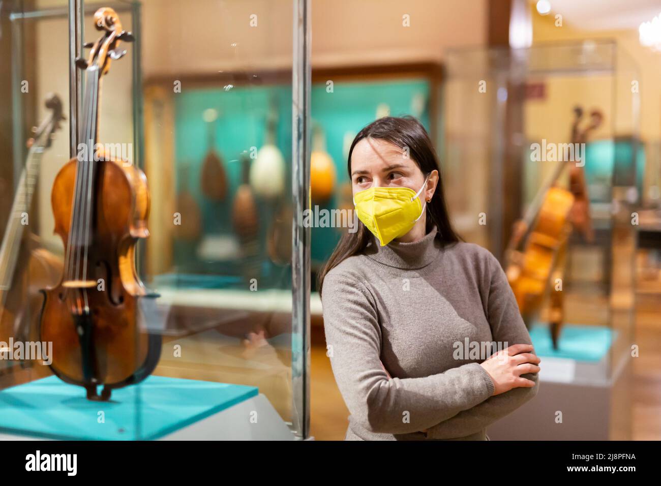 Brunette en masque de protection visite exposition d'instruments de musique médiévaux Banque D'Images