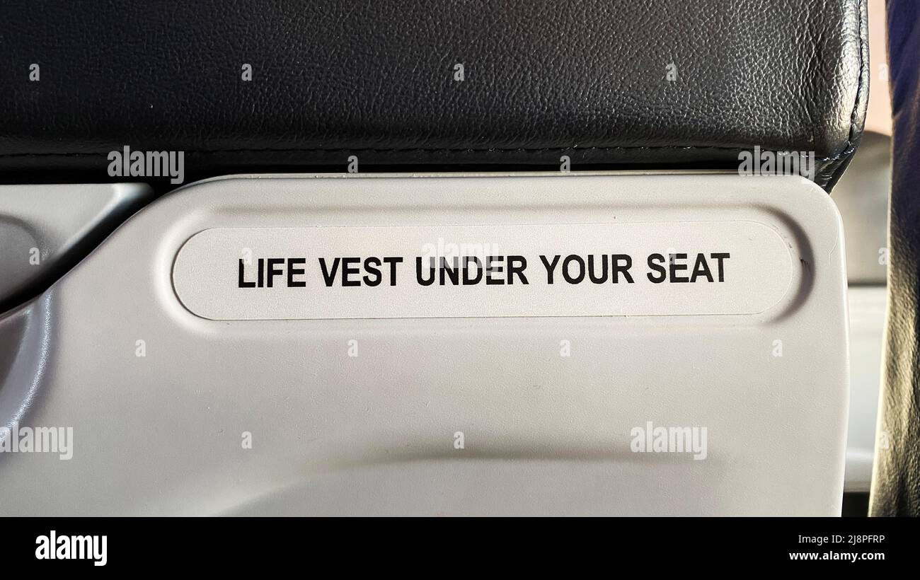 Un panneau « gilet de sauvetage sous votre siège » sur un avion Banque D'Images