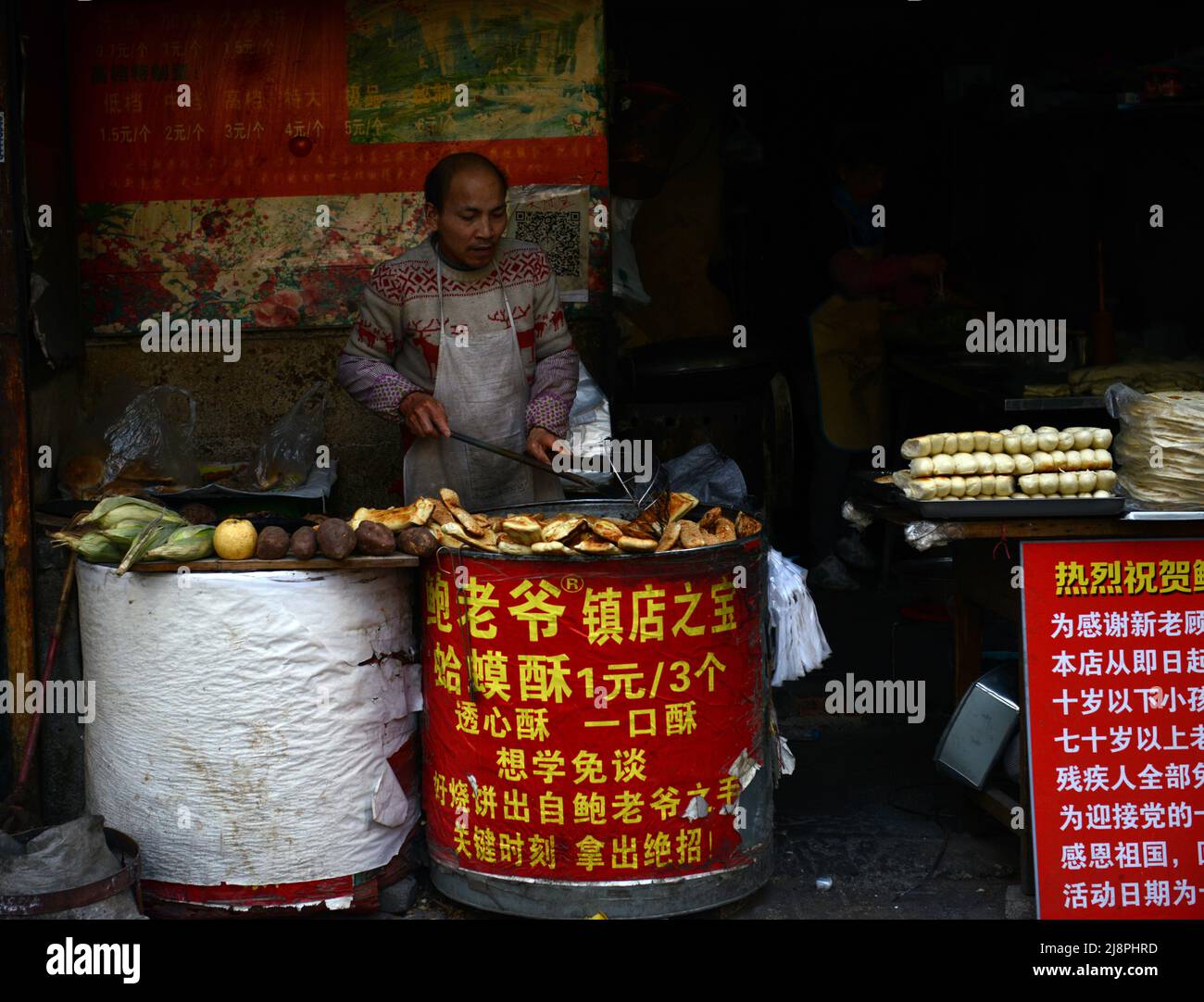 Un homme chinois qui cuit des pâtisseries dans un four en tandoor à Nanjing, en Chine. Banque D'Images
