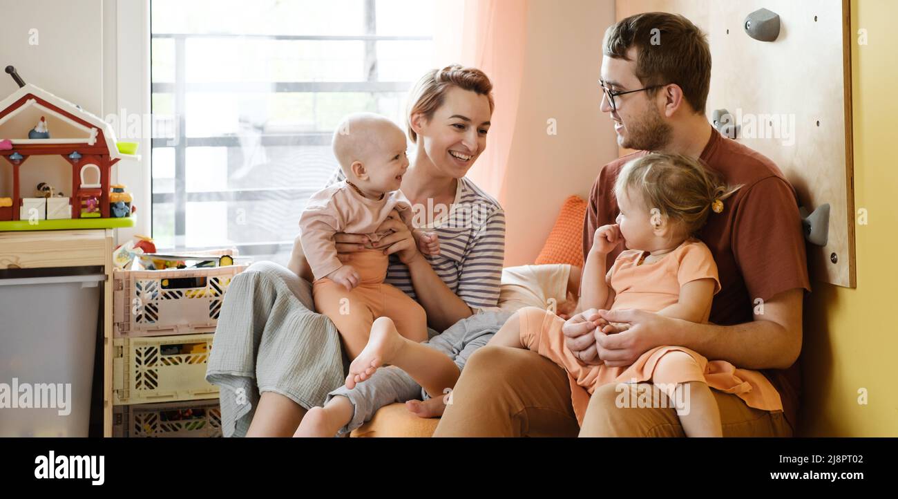 Grande famille dans une salle de jeux ensoleillée. Parents jouant avec des enfants et des jouets. Joyeux temps avec les jeux. Mère père fils filles dans une maison moderne colorée Banque D'Images