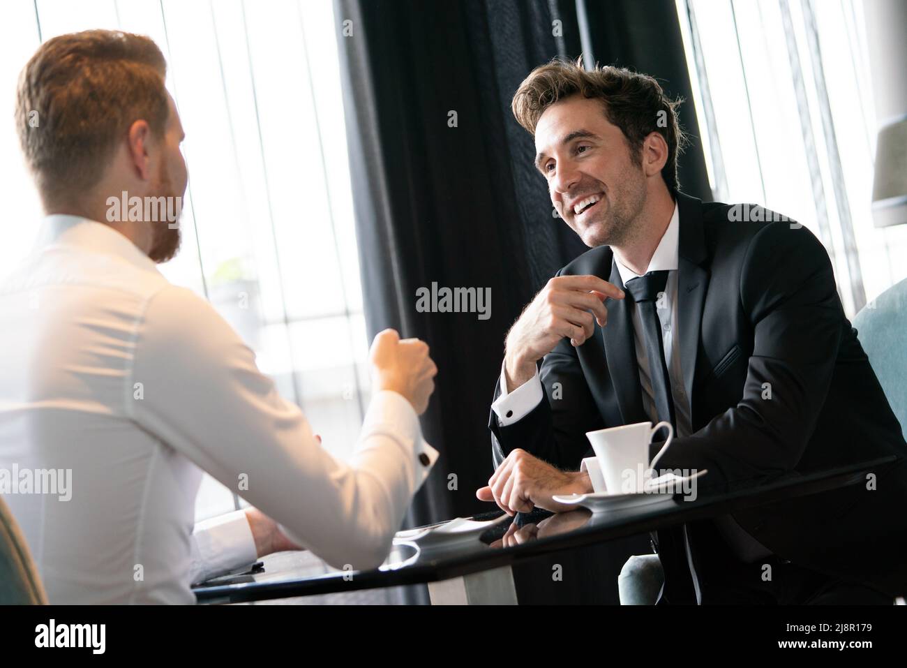 Businessman smiling réussie tout en discutant avec son partenaire au cours de réunion à Pause café Banque D'Images