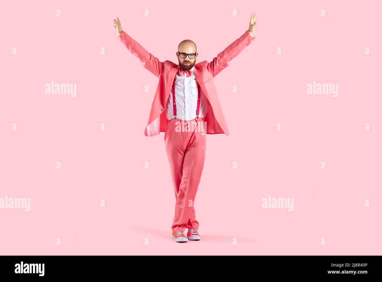 Homme dansant en costume rose en studio Banque D'Images