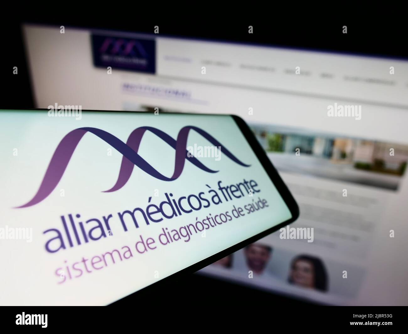 Smartphone avec logo de la société brésilienne de soins de santé Grupo Alliar sur écran devant le site Web d'affaires. Concentrez-vous sur le centre de l'écran du téléphone. Banque D'Images